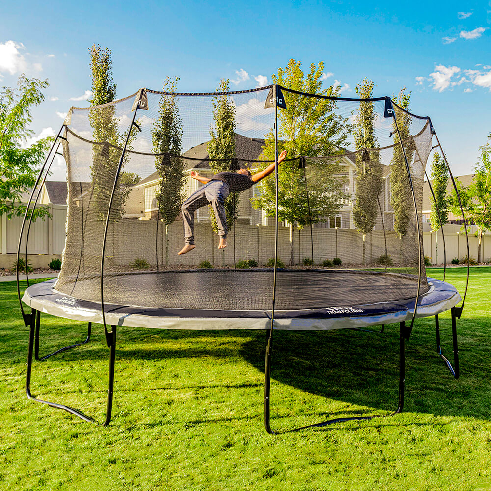 Teenage boy flops backward onto the 16-foot round Epic Series Trampoline.