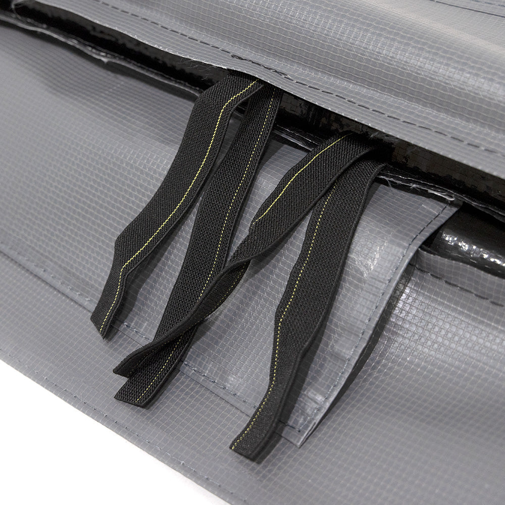A view of the straps peeking out from in between the spring pad's layers.