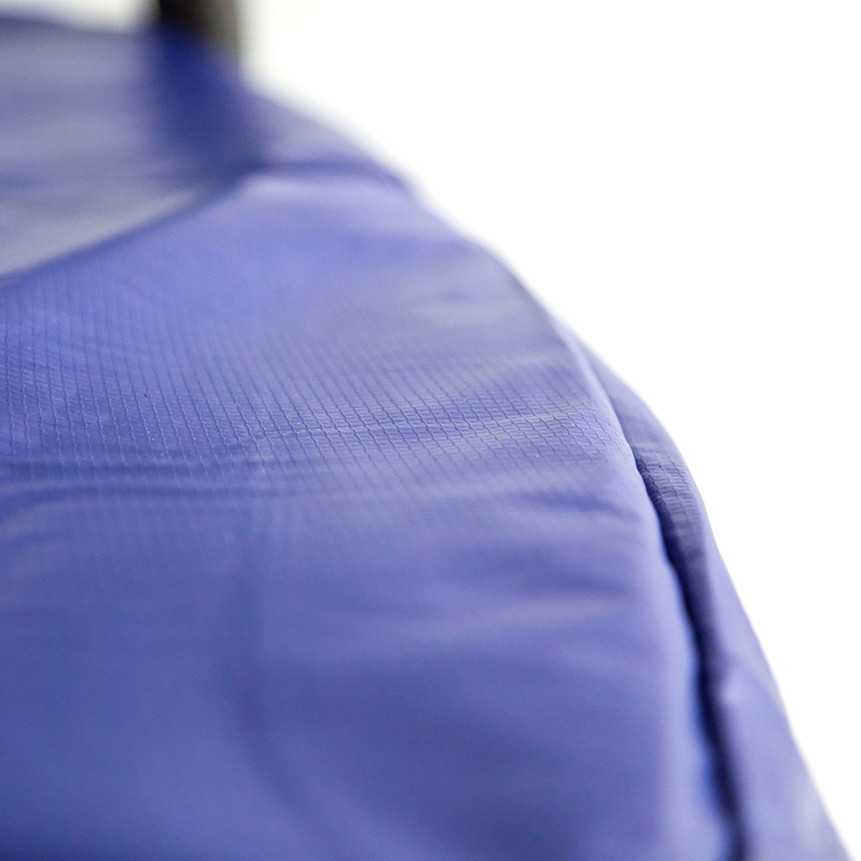 Close-up view of the blue spring pad on the trampoline. 