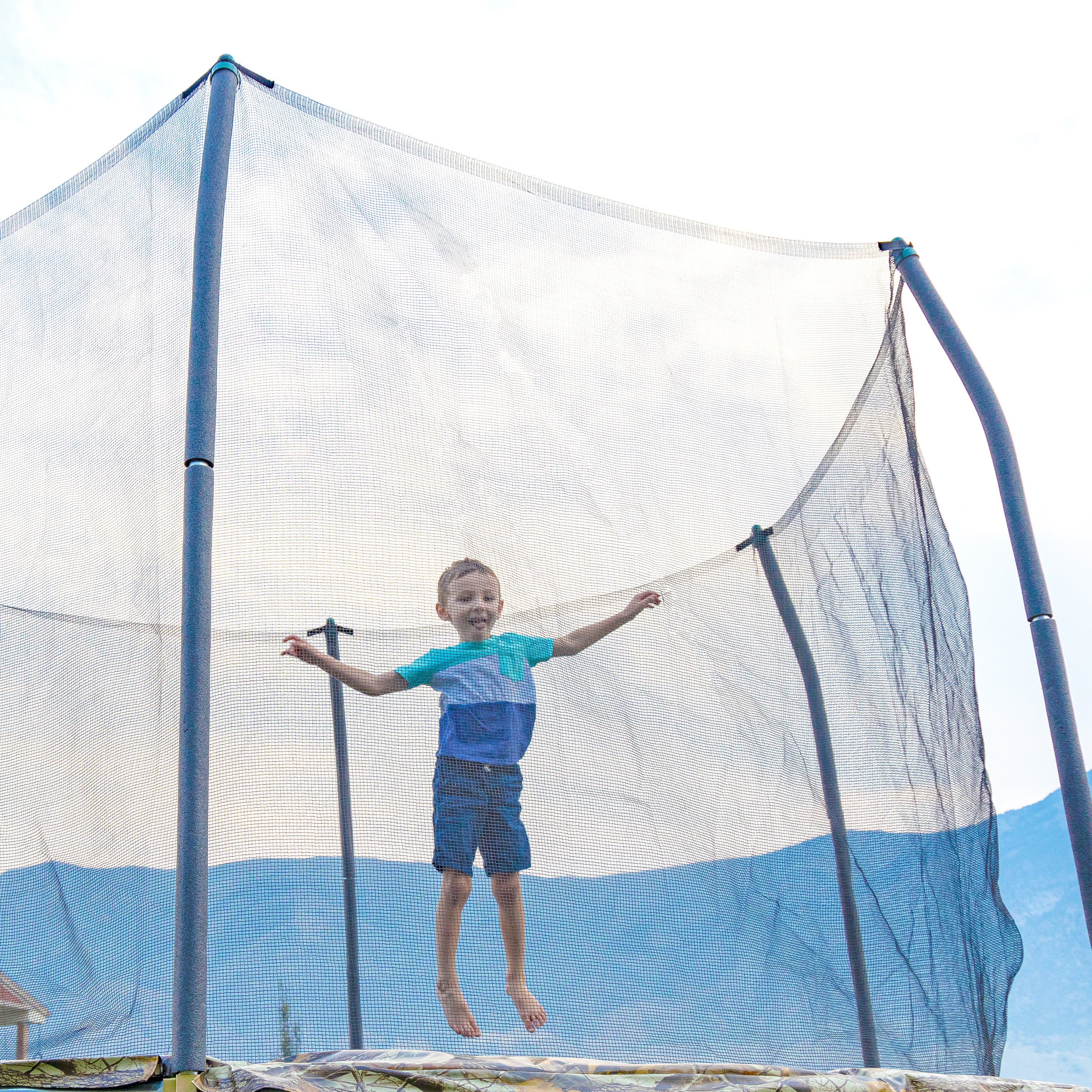 A closer view of the little boy jumping on the 12-foot round camo trampoline.