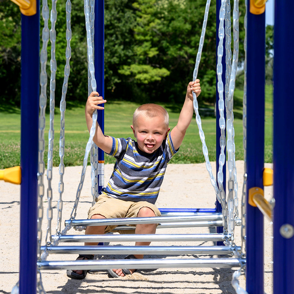 A small boy sits on the playset's suspended steps while hanging onto the plastic-coated chains.