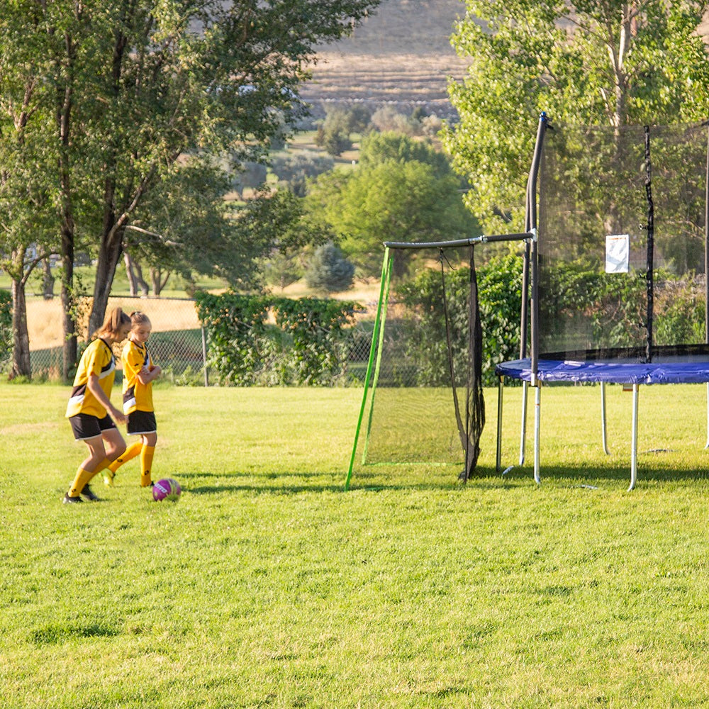 Two girls play soccer with the Multi-Sport Training Net. 