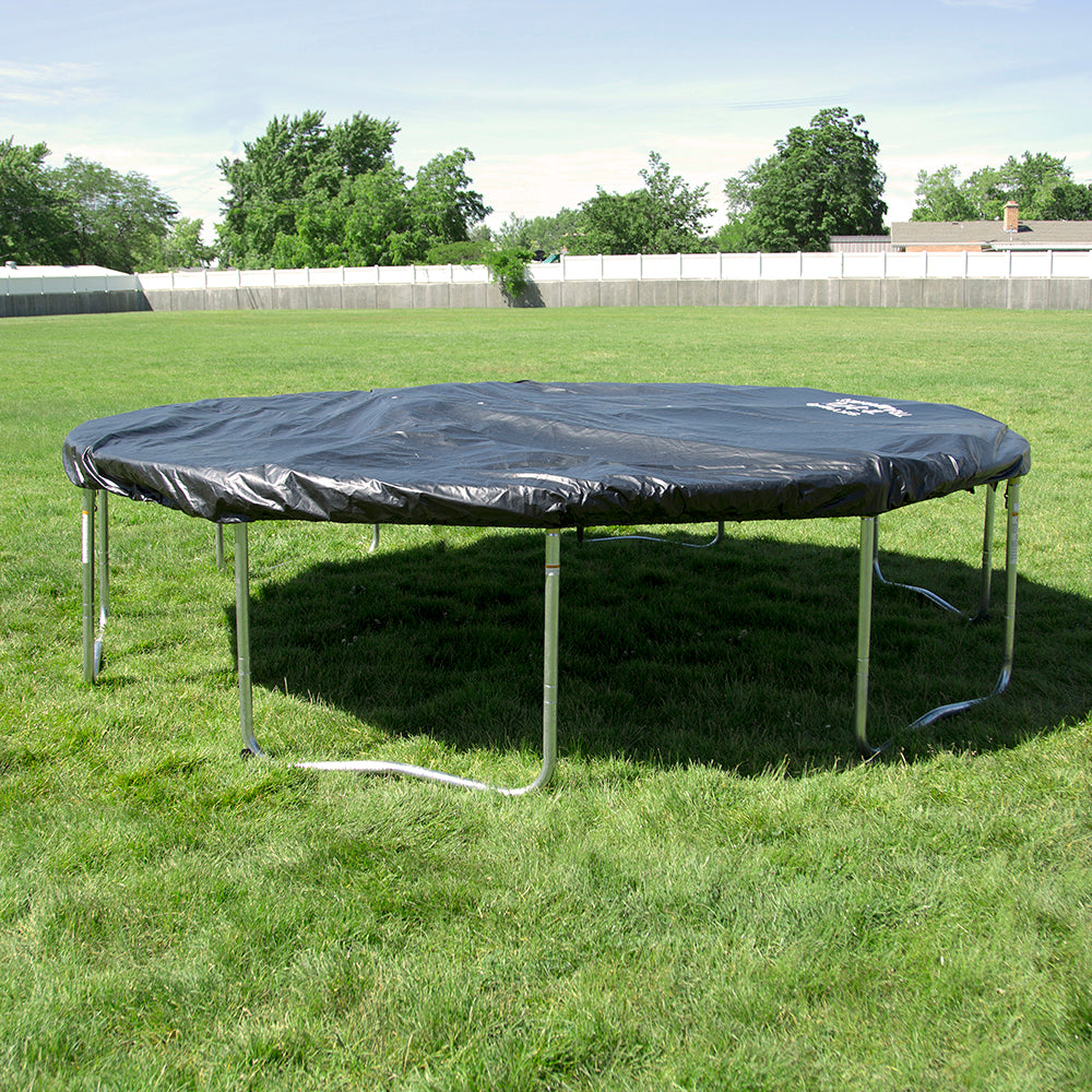 A 12-foot round trampoline with the weather cover on it sits in a grassy backyard. 