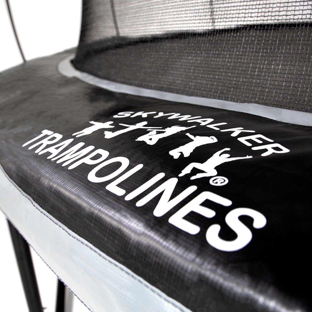 The white Skywalker Trampolines logo printed on the black and gray spring pad. 