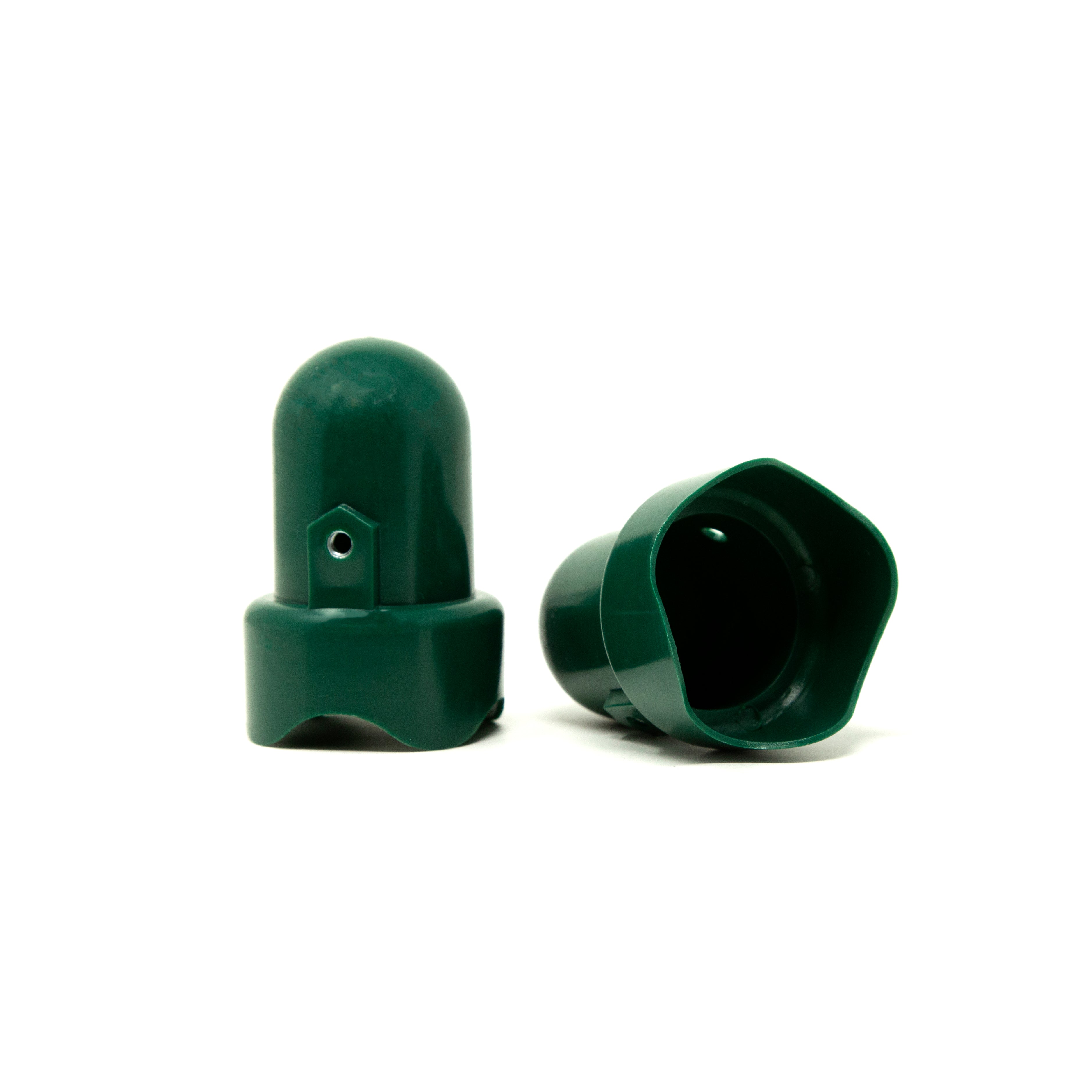 Two green pole caps, one lying on its side. 