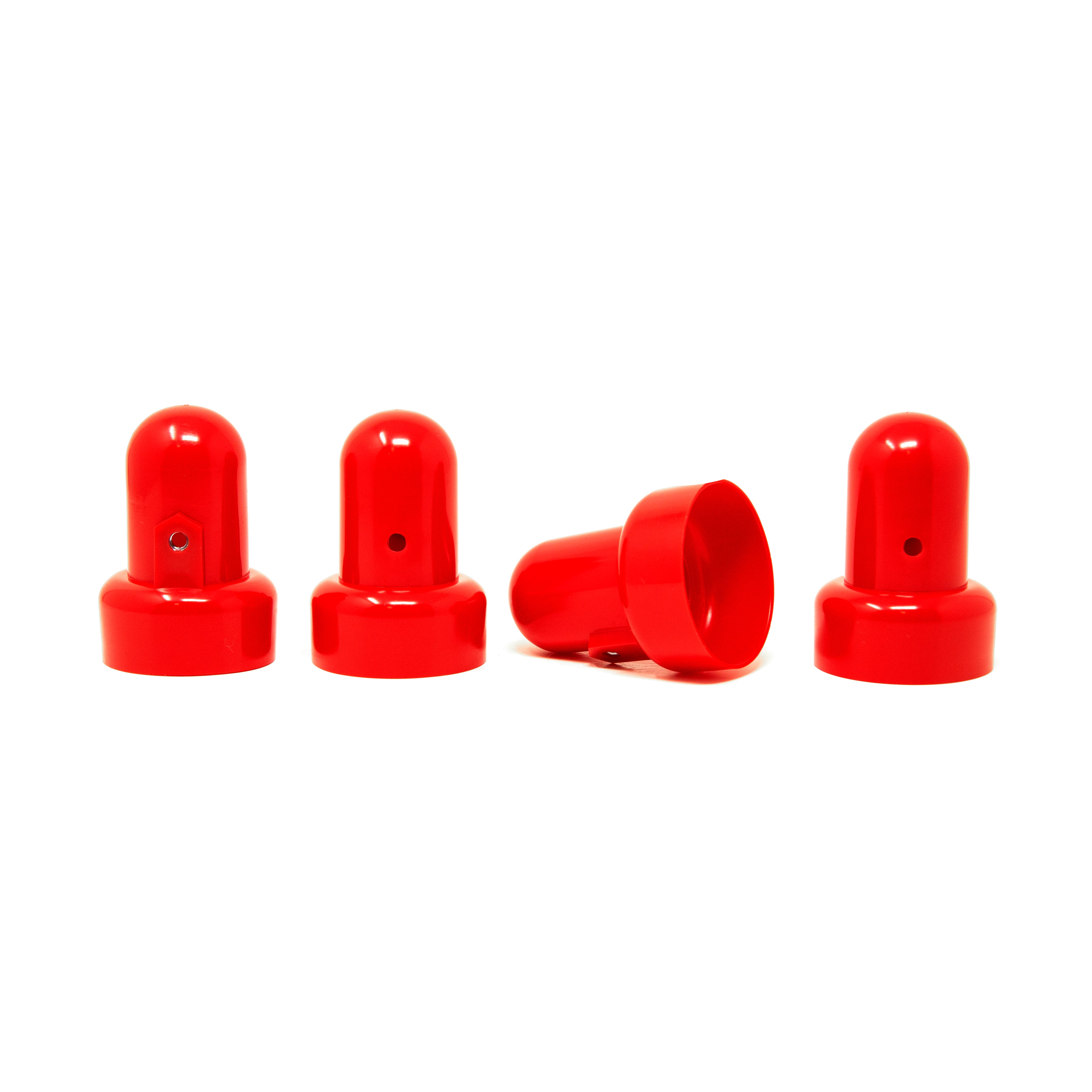 Four red pole caps with one pole cap lying on its side. 