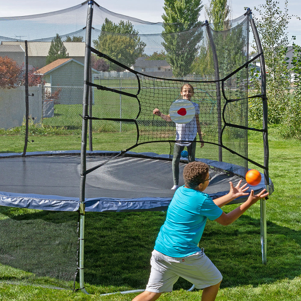 Boy throws mini basketball at the Bounceback net.