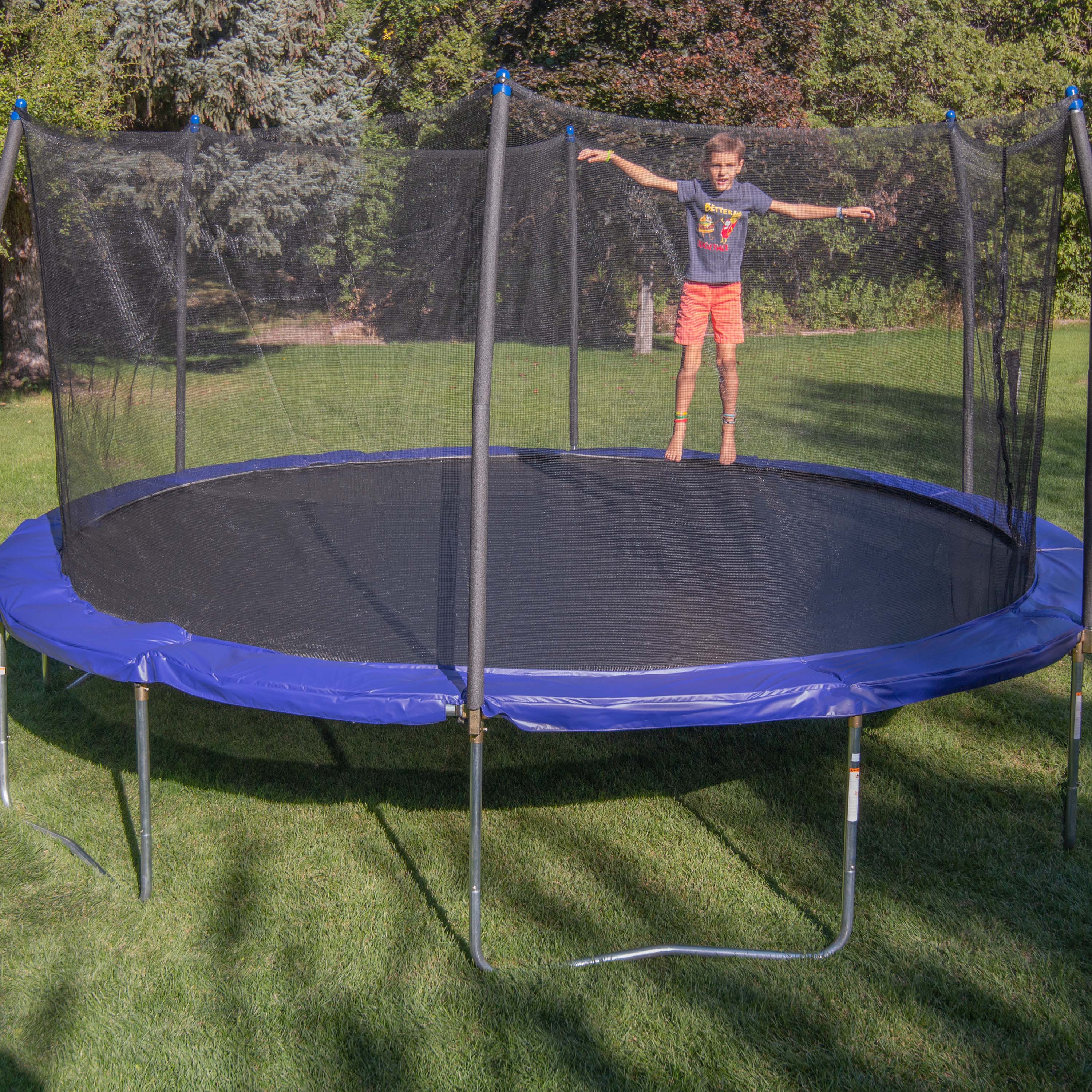 Boy jumping on the outdoor 16' Round Skywalker Trampoline. 