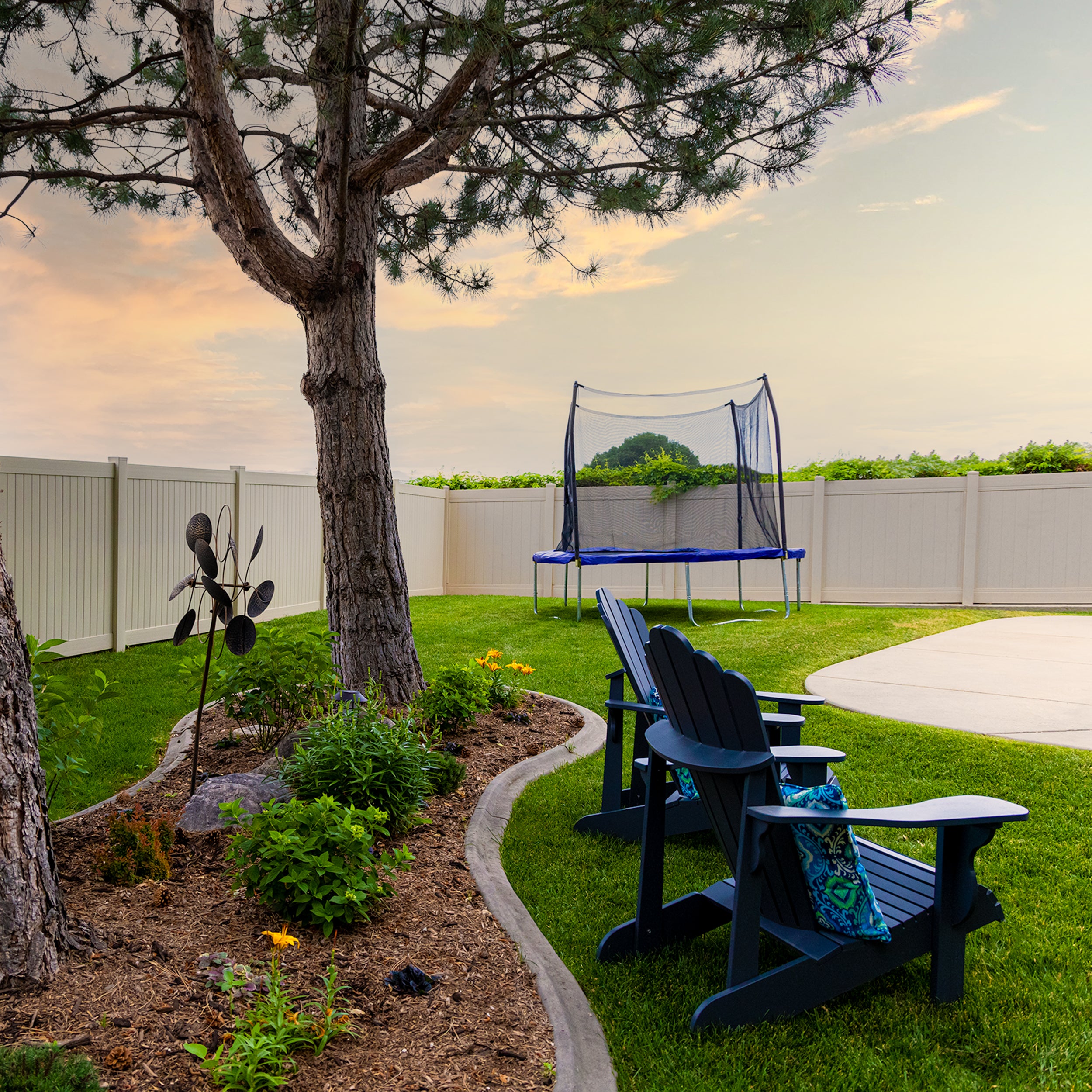 The blue 10-foot round trampoline sits next to a tree and patio chairs. 