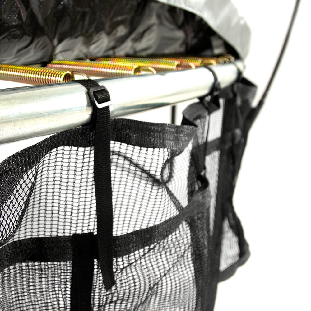Spring pad is lifted up to show how the Three Pocket Accessory Storage Bag is strapped on the trampoline frame. 
