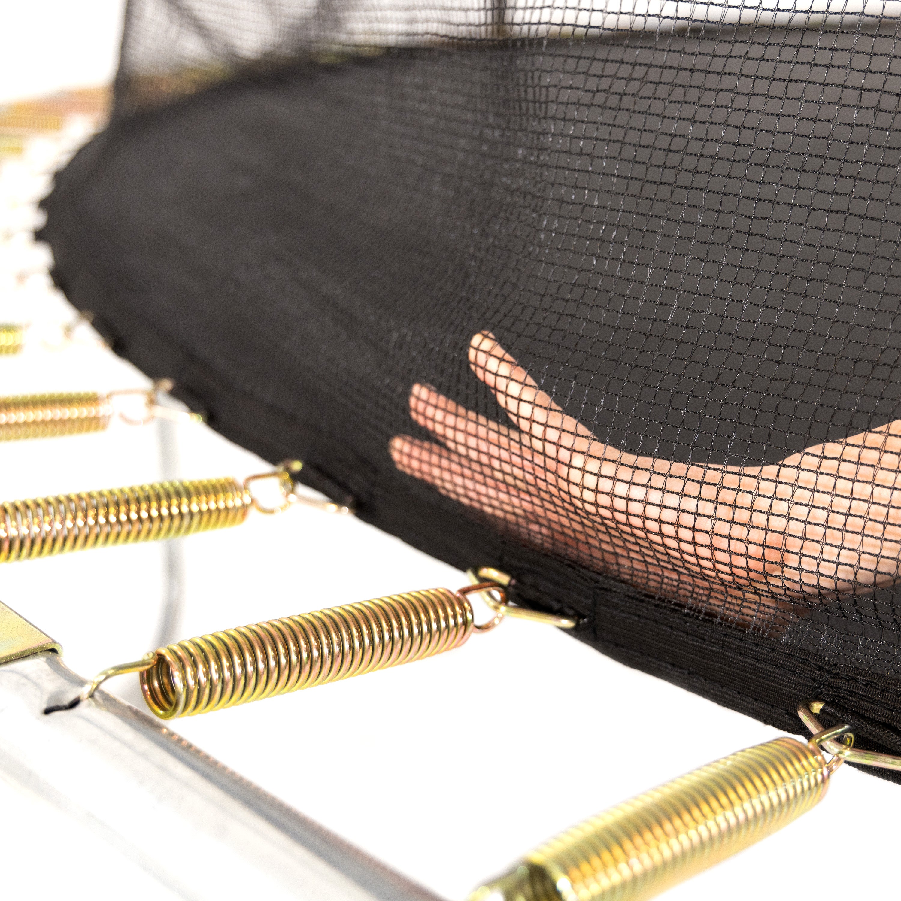 A hand presses at the spot that the springs, jump mat, and enclosure net meet. 