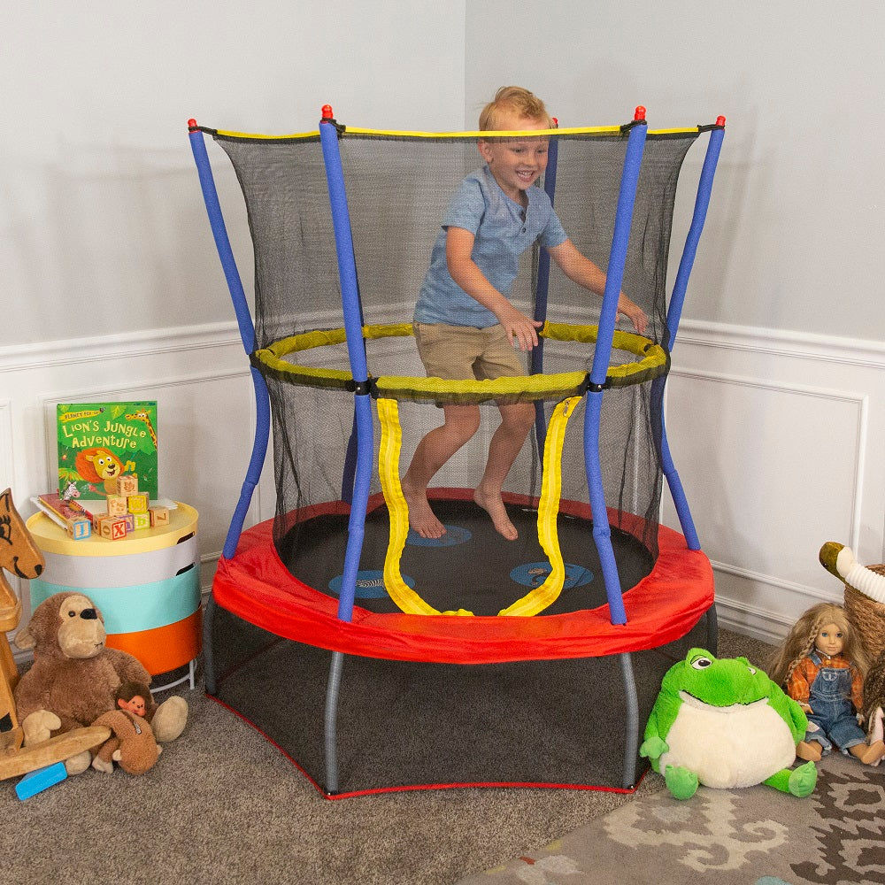 Boy excitedly jumps on blue, red, and yellow 48-inch mini kids trampoline. 