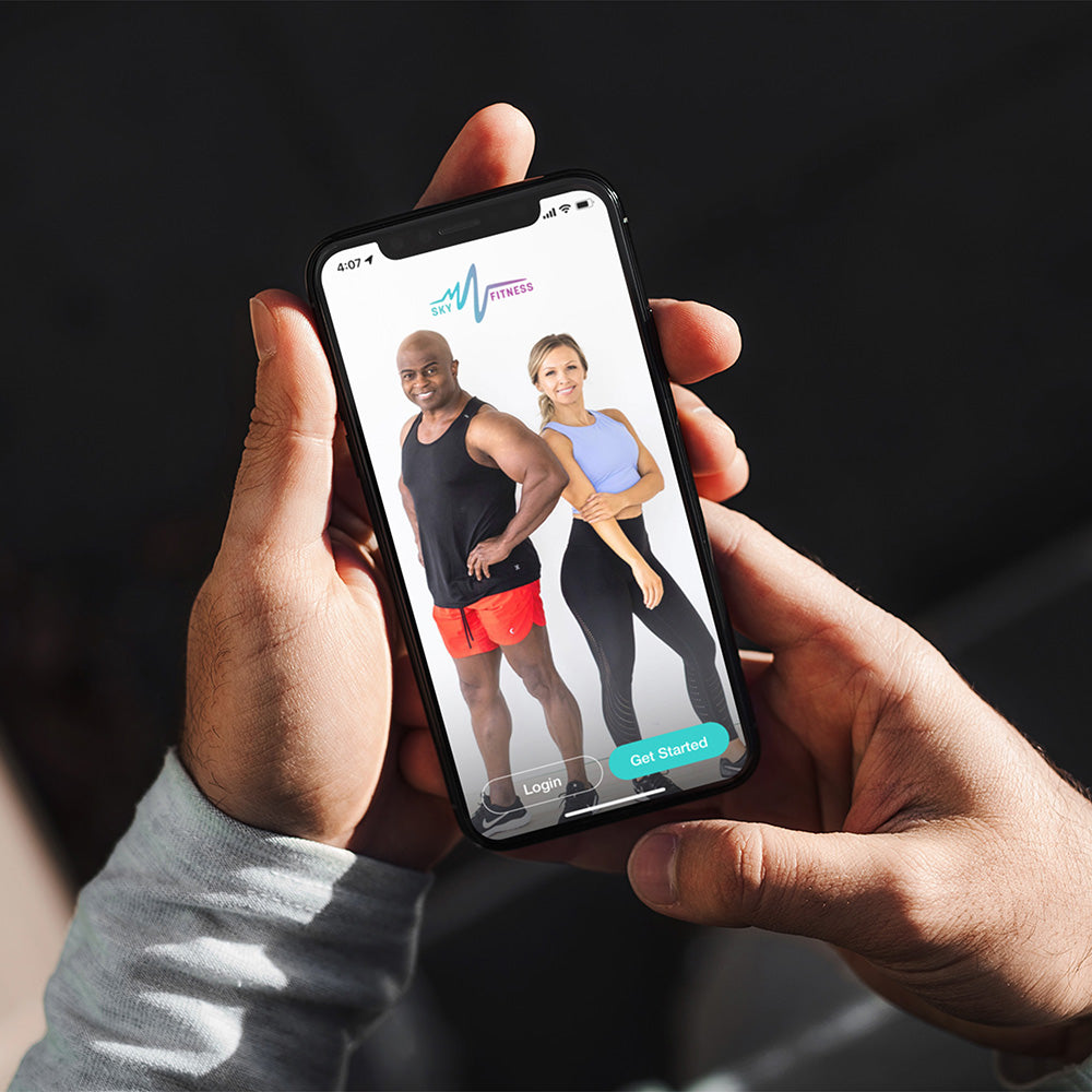 Hands are holding a phone that has the screen open to the SkyFitness app. 