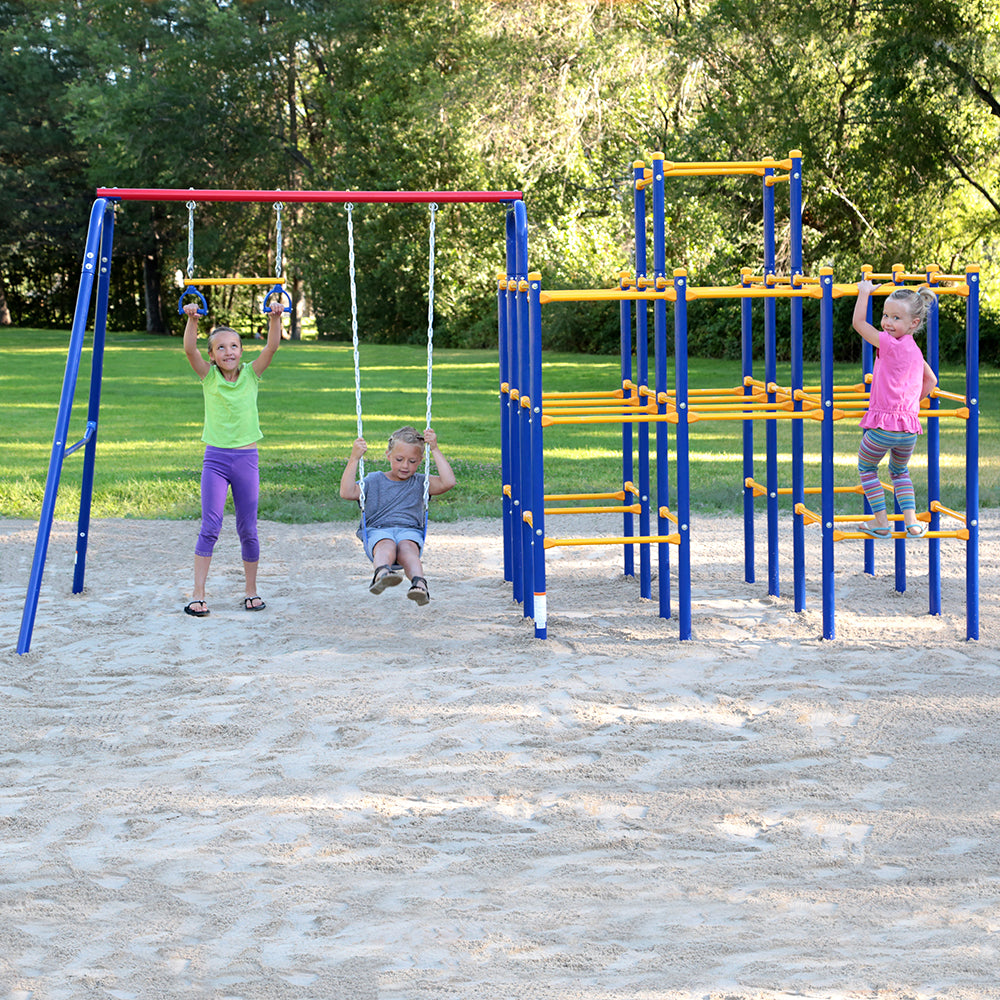 Two young girls play on the swing set while another young girl climbs on the jungle gym base. 