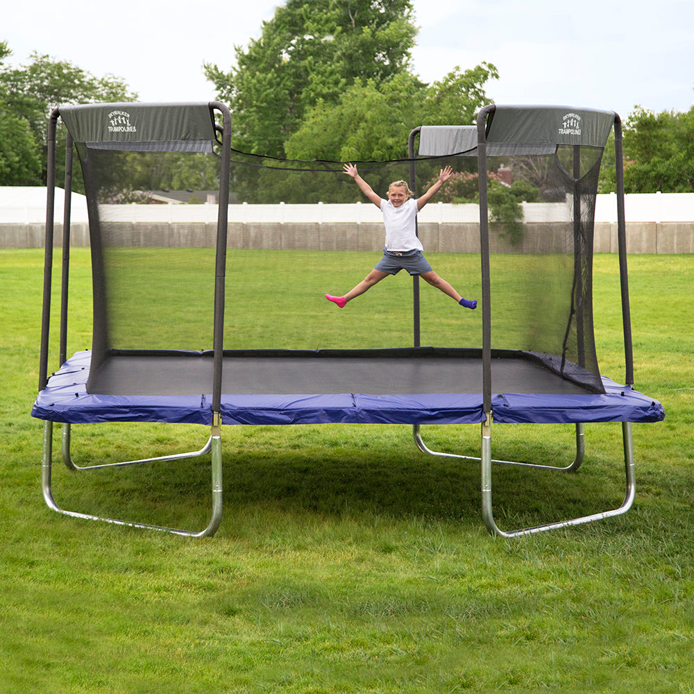 Young girl jumps with limbs wide on the 16-foot premium trampoline. 