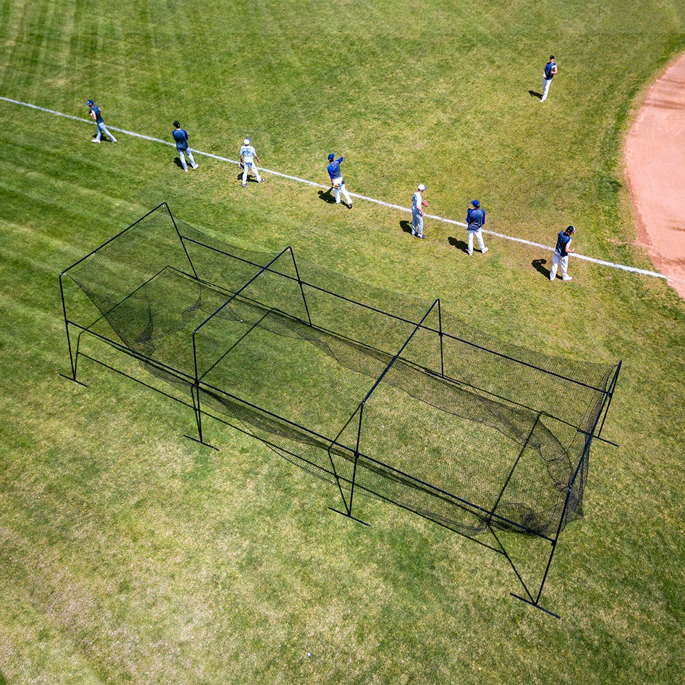 Birdseye view of baseball players lined up next to the batting cage. 
