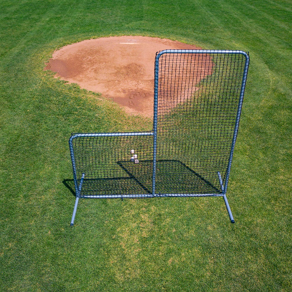 The 6-foot-tall Pitcher's L-Screen sits in front of baseballs on the baseball field. 