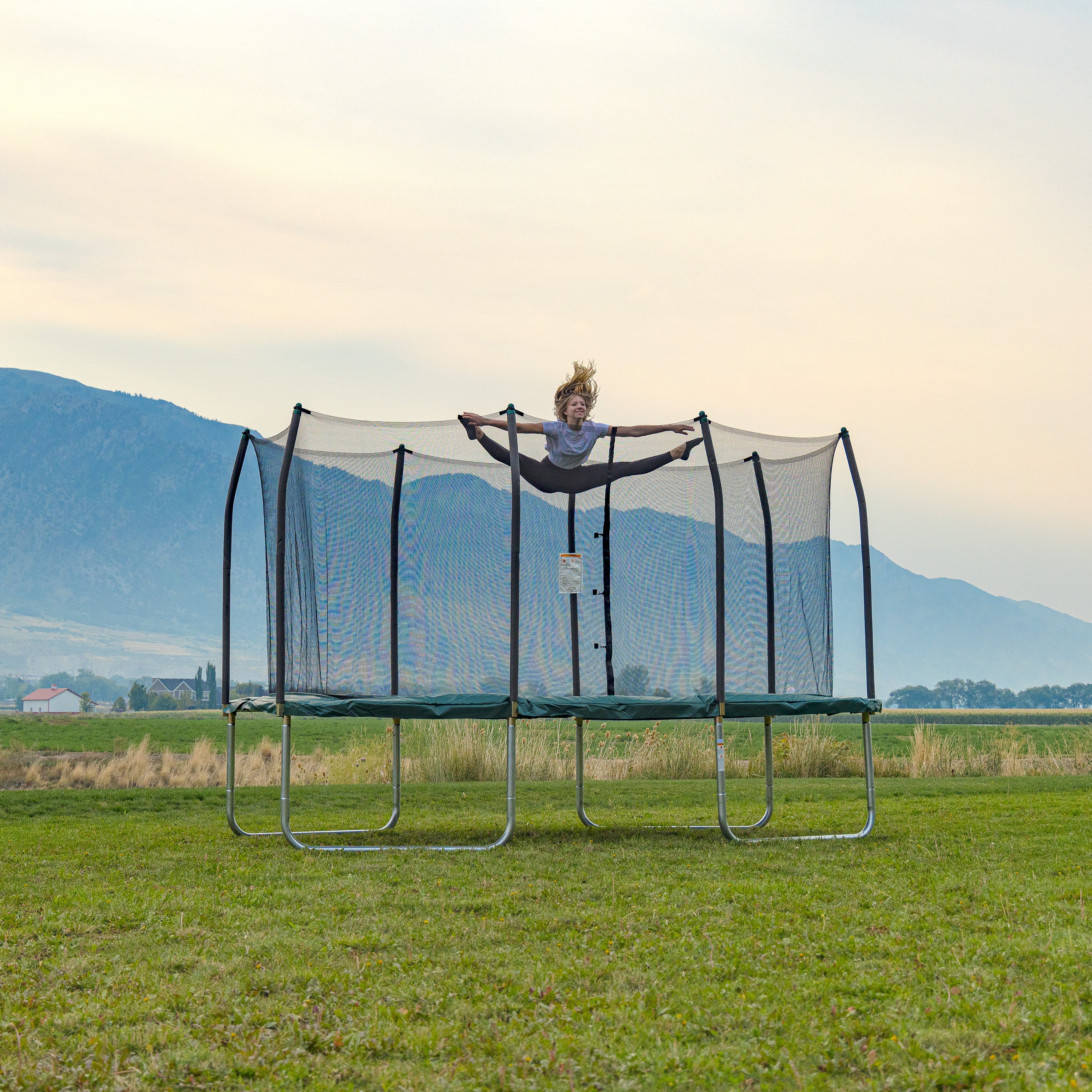 Teenage girl does the jumping splits on the 14-foot rectangle trampoline. 