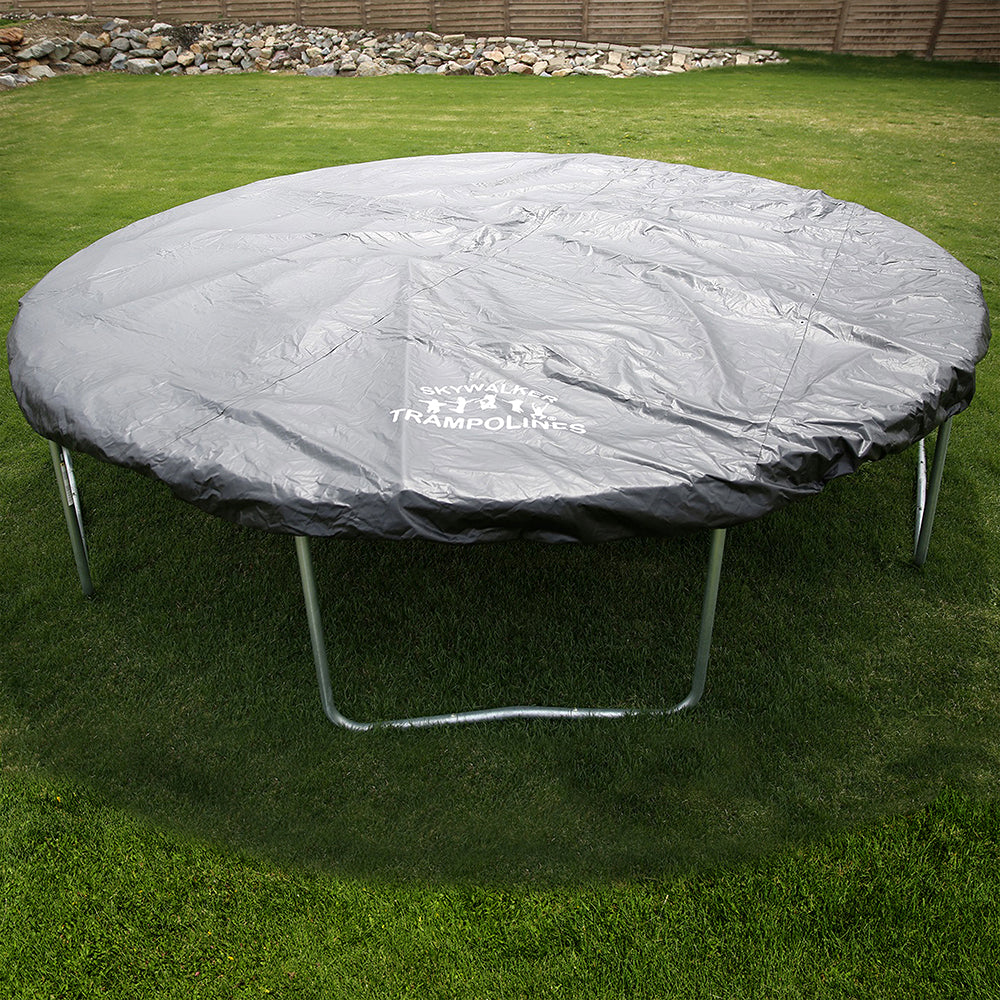 Trampoline with black weather cover sits in a backyard.