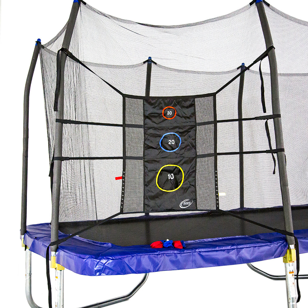Triple Toss Game is tied to the enclosure poles of rectangle trampoline. Red and blue bean bags sit on trampoline spring pad. 