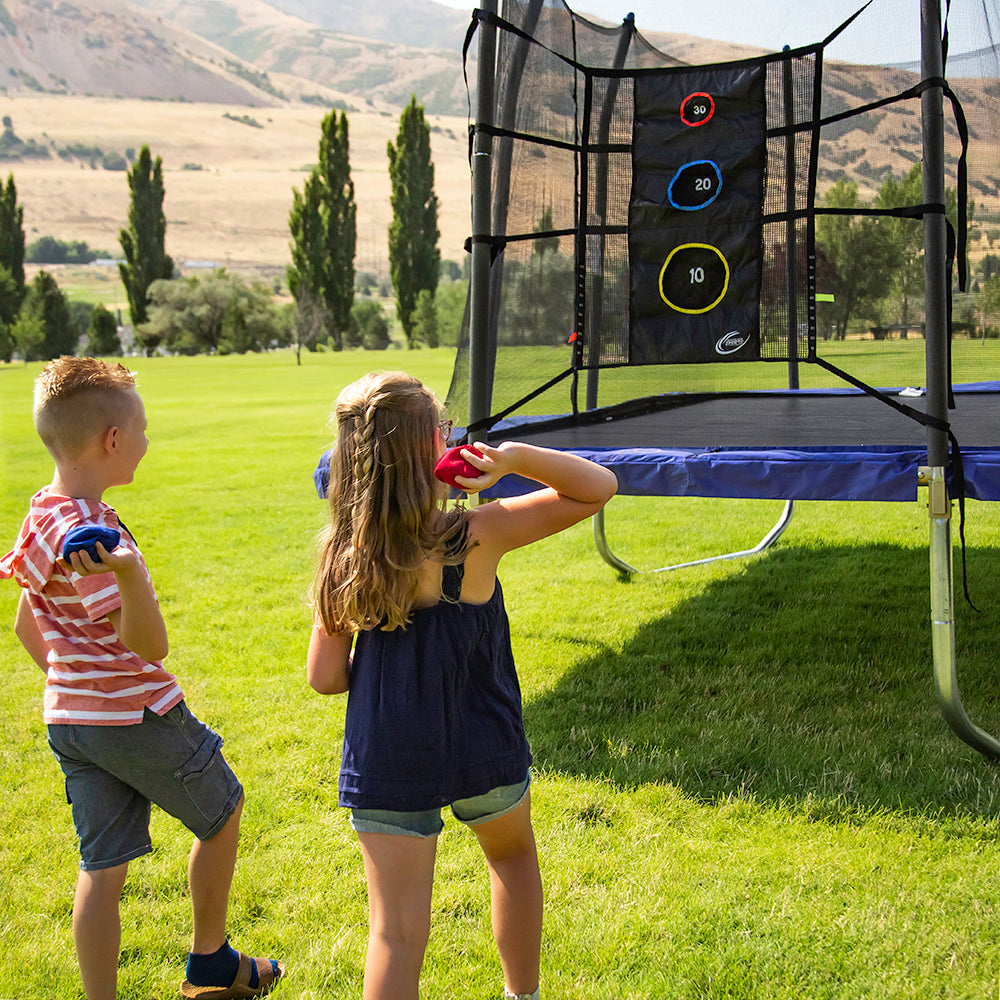 Two children throw bean bags at the Triple Toss Game. 