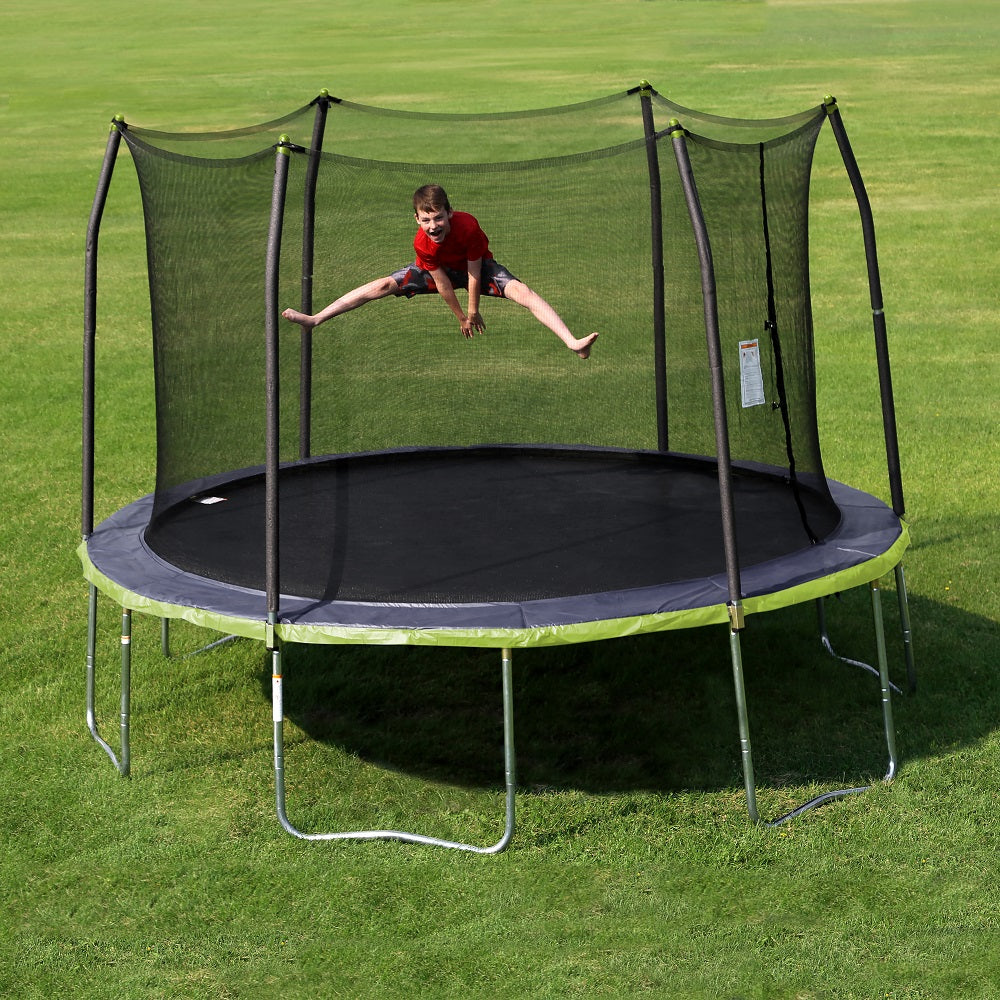Boy doing the splits on the 13-foot round kids trampoline with dual color spring pad. 