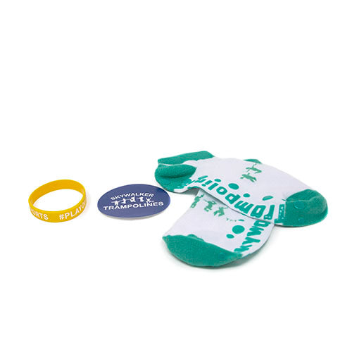 Yellow silicone wristband with hashtag on it, blue Skywalker Trampolines sticker, and green Skywalker Trampolines socks. 