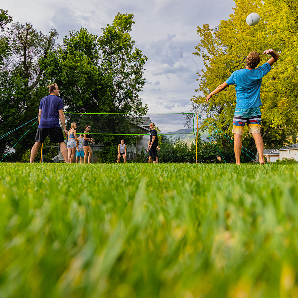 Group of people playing volleyball with the Skywalker Sports volleyball kit. 